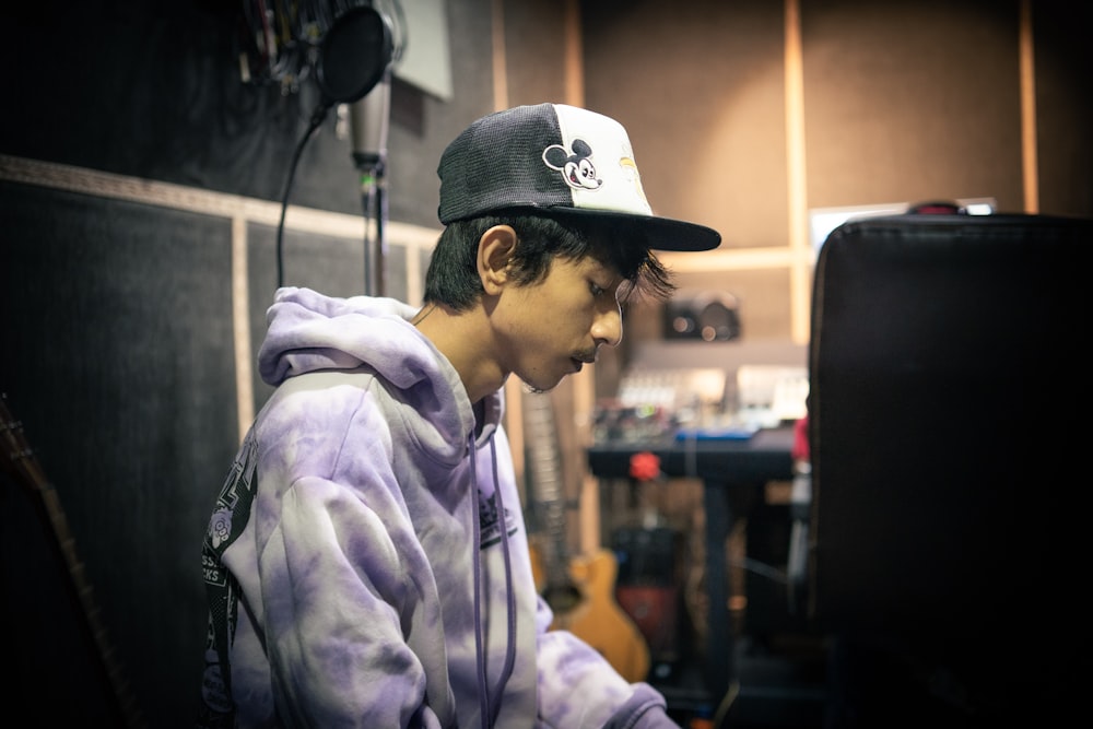 a young man wearing a purple hoodie and a black hat