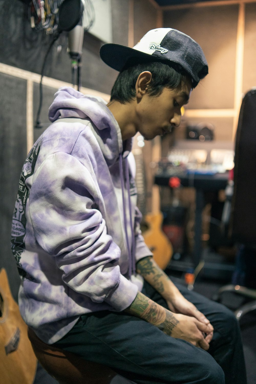 a man sitting on a stool in a recording studio