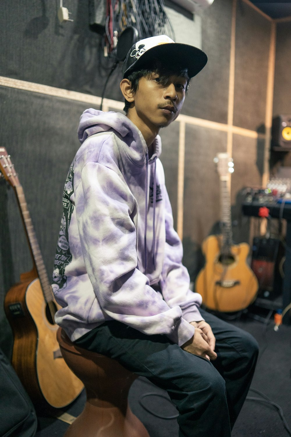 a young man sitting on top of a guitar