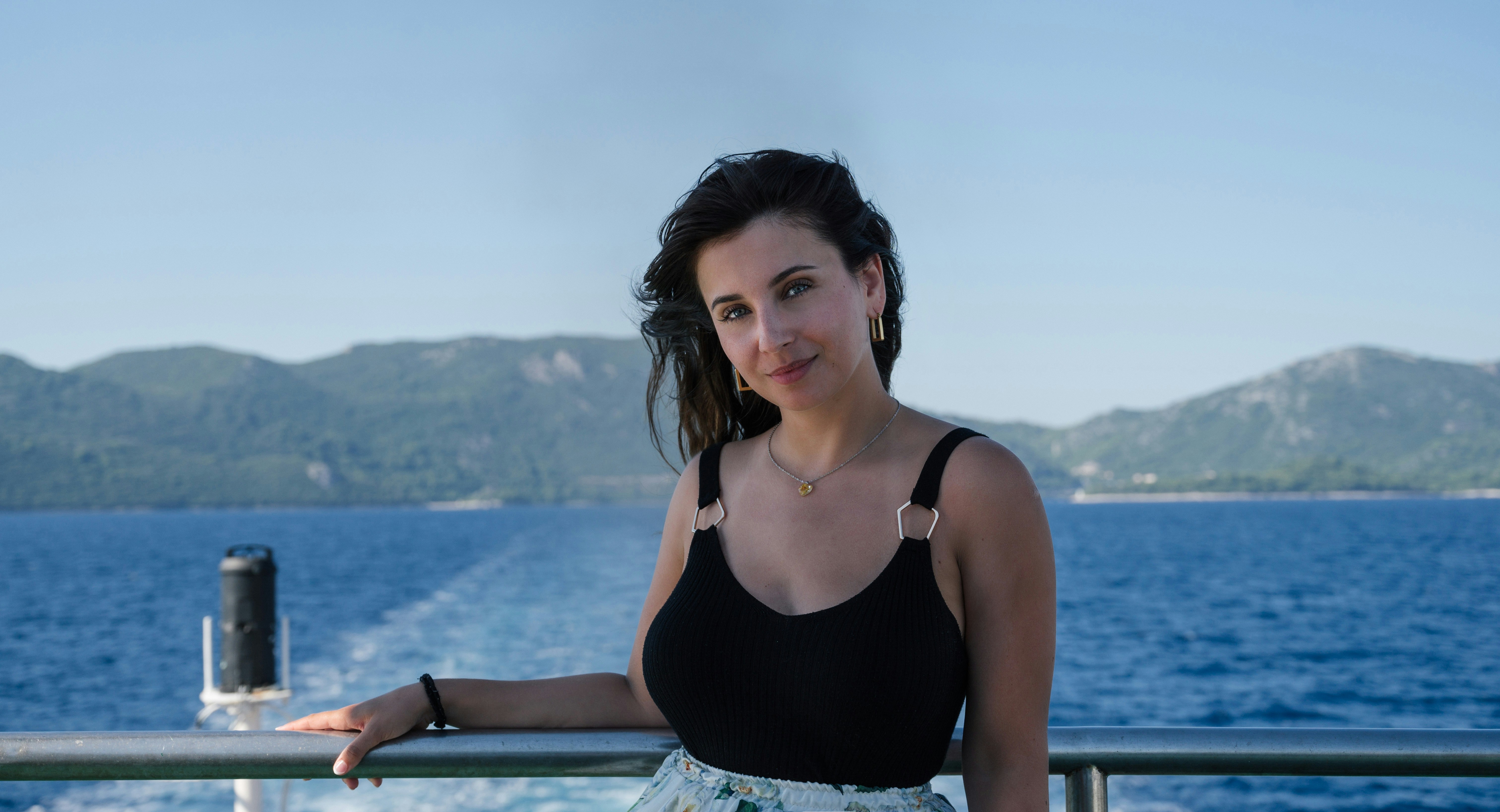 a woman standing on a boat looking at the camera