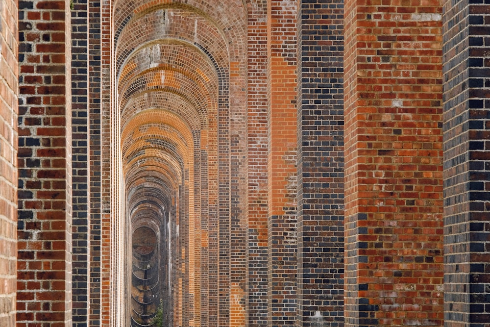 a group of people walking through a brick tunnel
