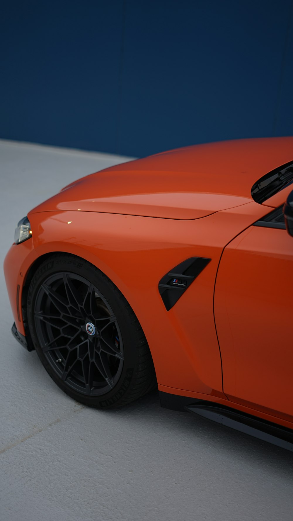 an orange sports car parked in a parking lot