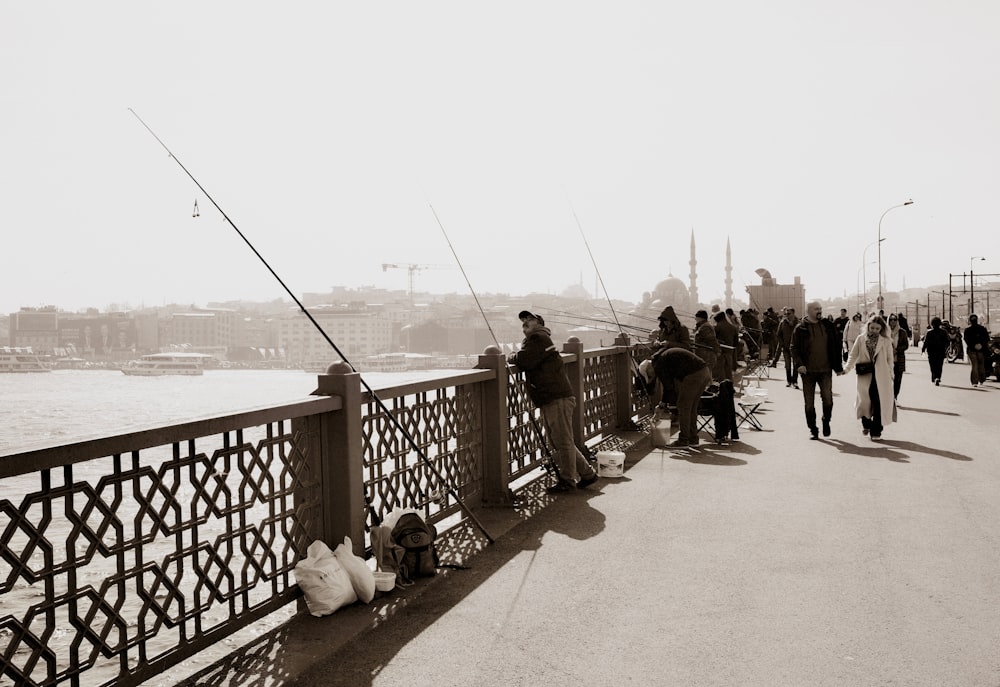 a group of people fishing on a bridge