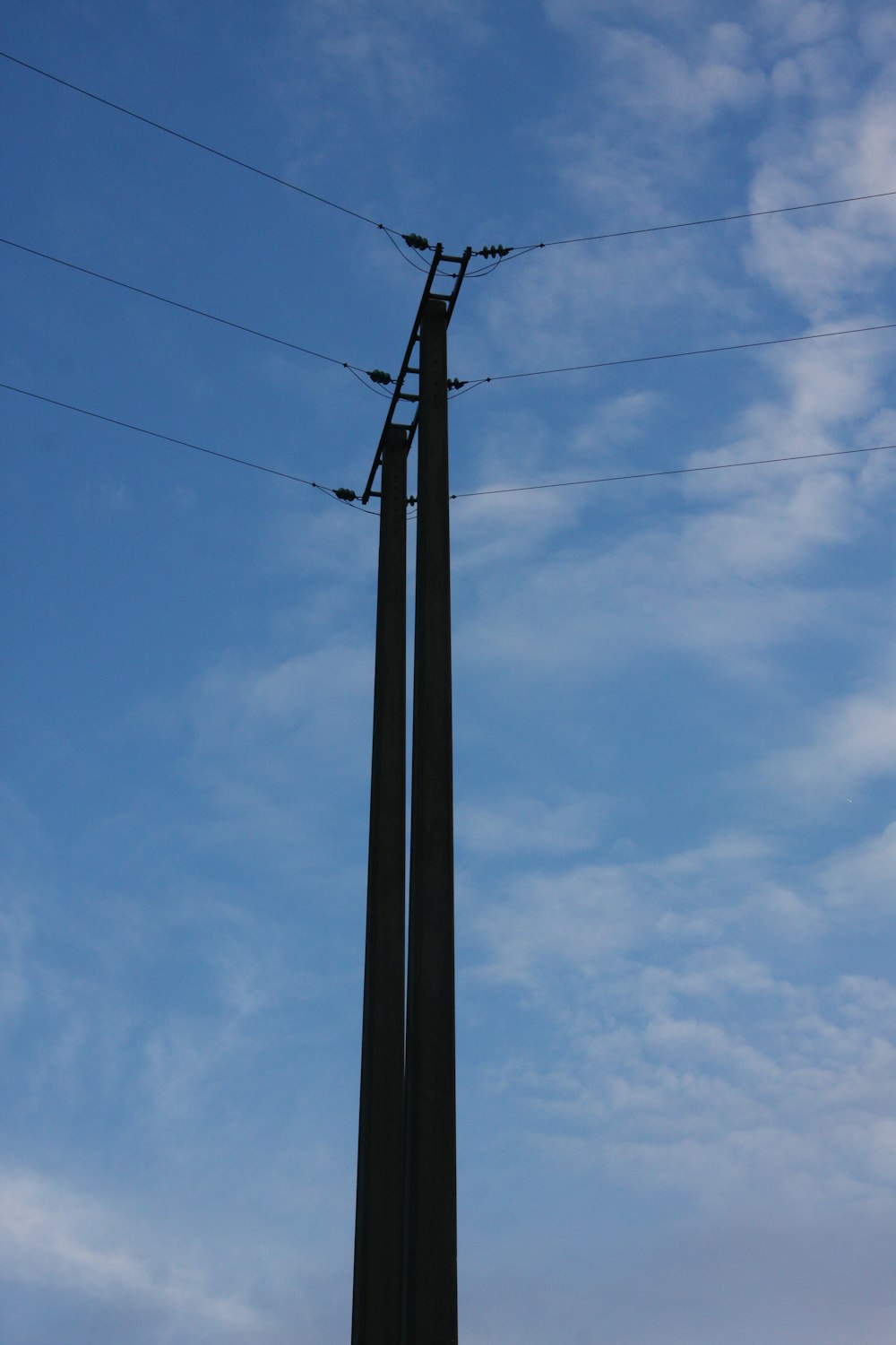 a tall metal pole with power lines above it