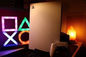 a video game console sitting next to a neon sign