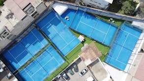 an aerial view of a tennis court and parking lot
