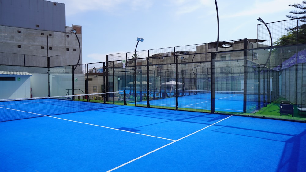 a tennis court with a blue tarp and a fence