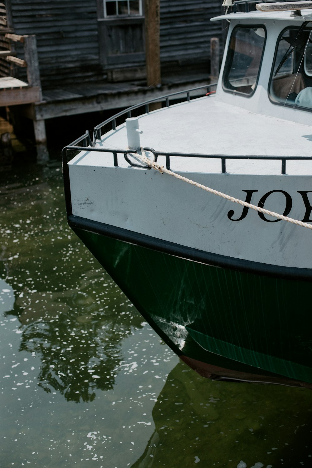 a white and green boat docked at a dock