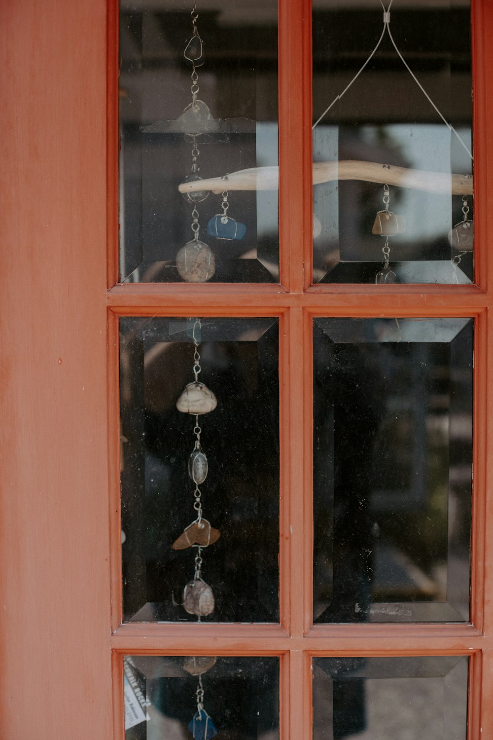 a close up of a window with beads hanging from it