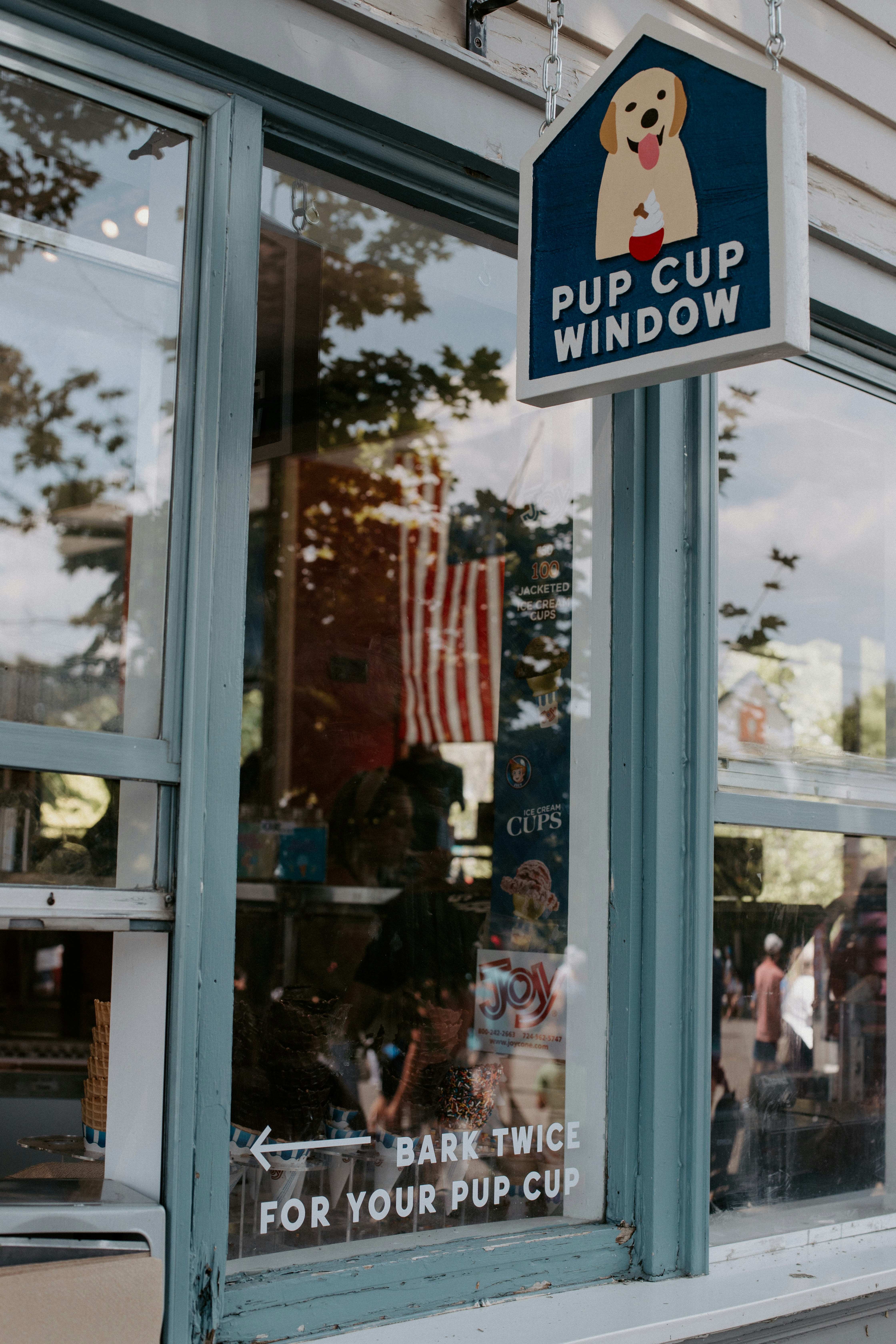 a sign on a store window that says pup cup window