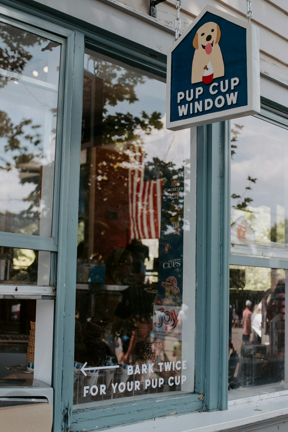 a sign on a store window that says pup cup window