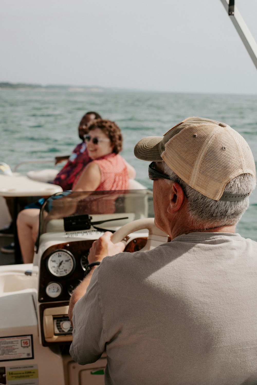 a man driving a boat with a woman on the back of it