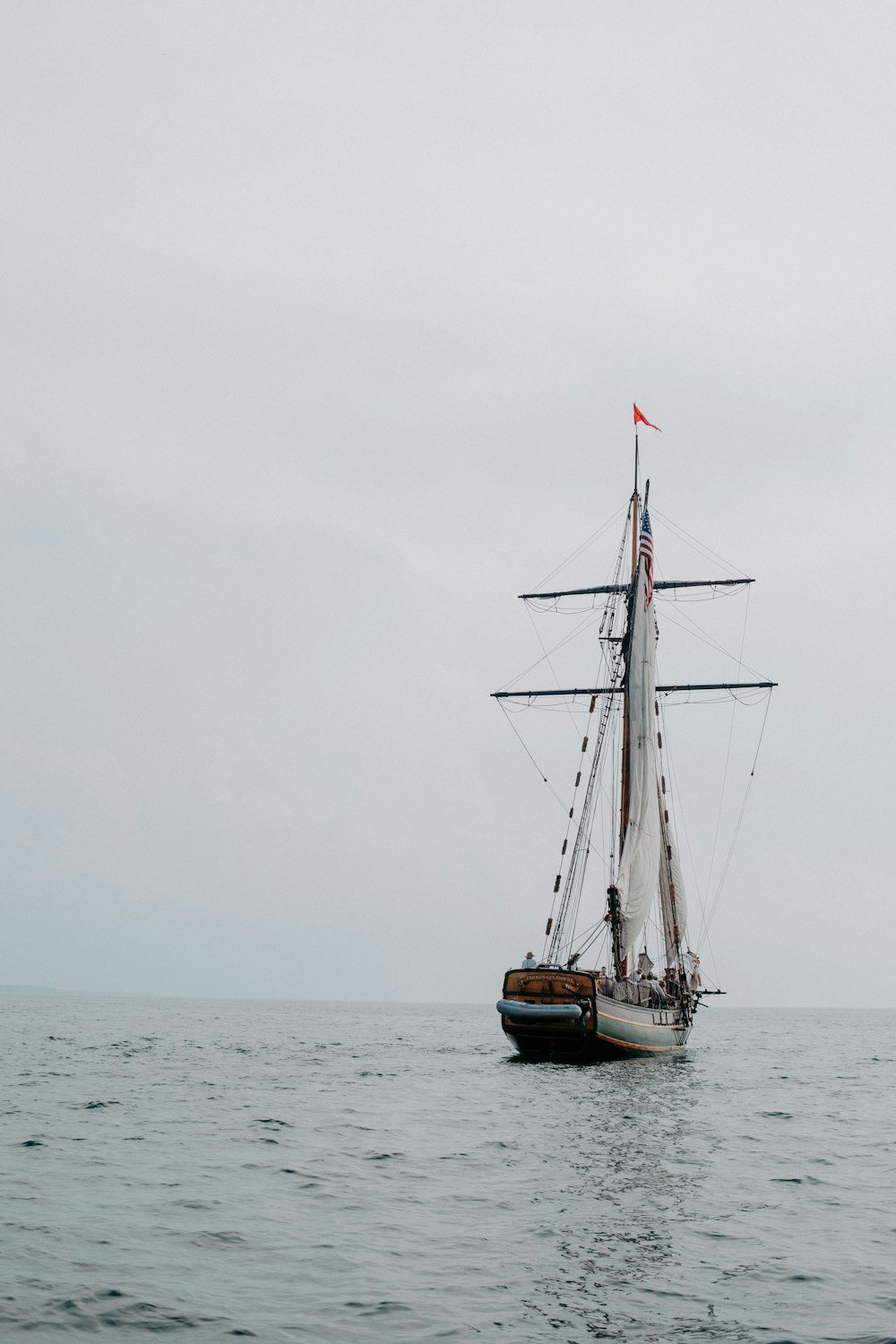 a sailboat in the ocean on a cloudy day