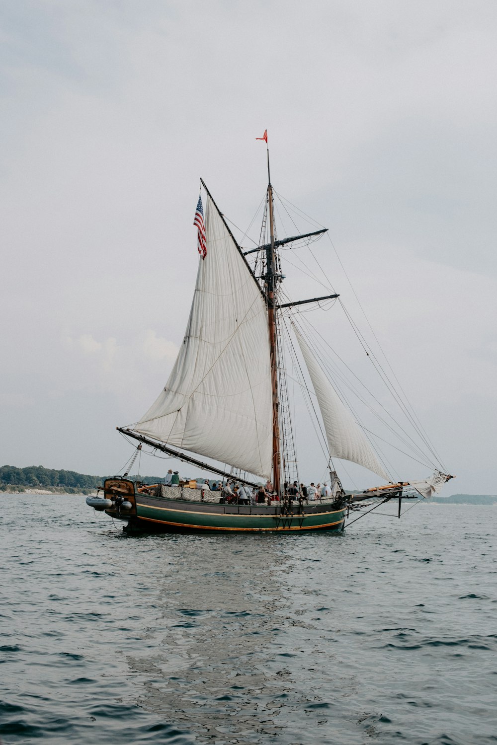 a sailboat with white sails on a body of water