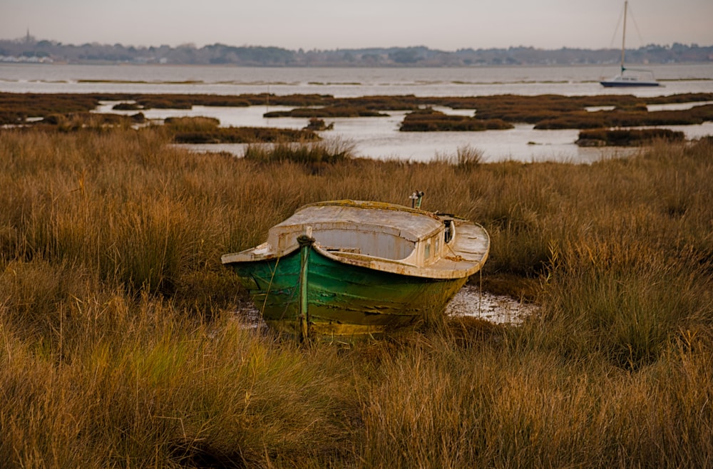 a boat sitting on top of a dry grass field