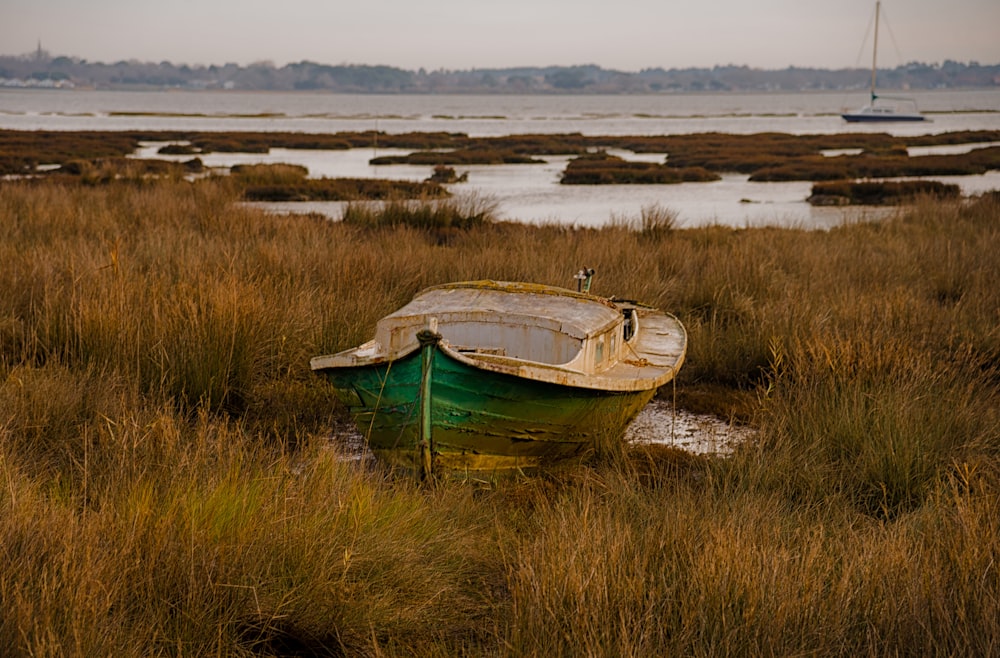 um barco sentado em cima de um campo de grama seca