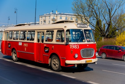 a red and white bus driving down a street