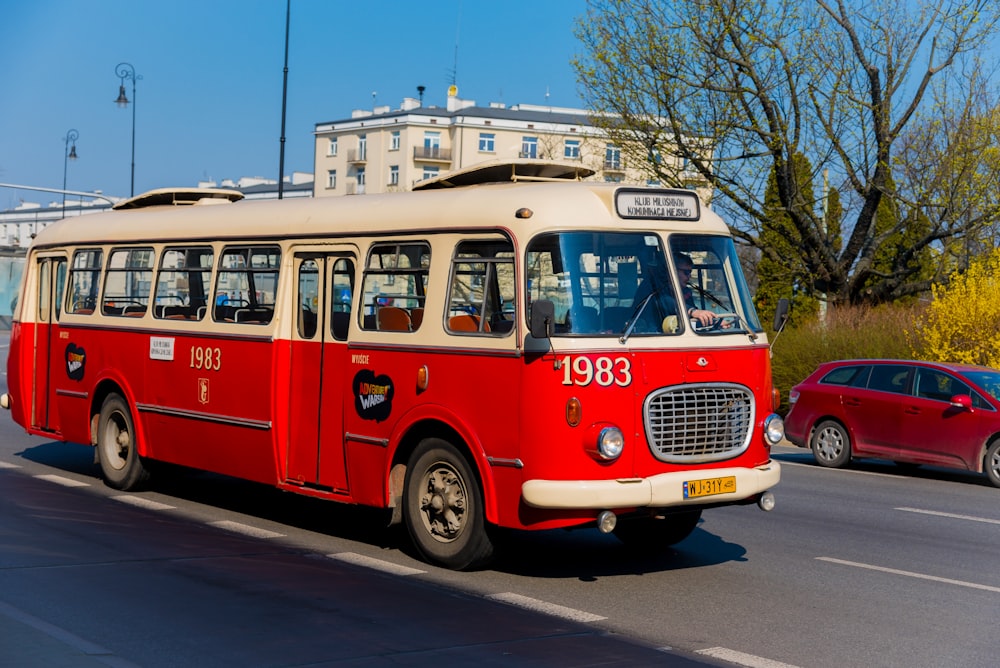 um ônibus vermelho e branco dirigindo por uma rua