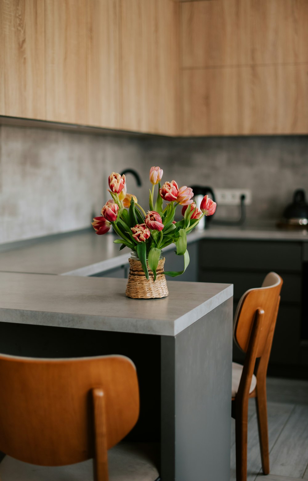 a vase of flowers sitting on a kitchen counter