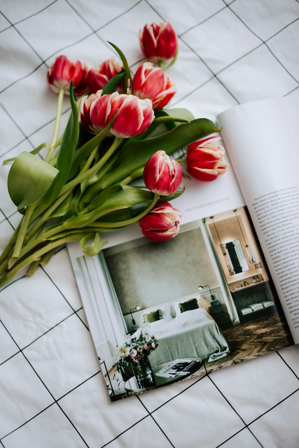 a bunch of red tulips sitting on top of a bed