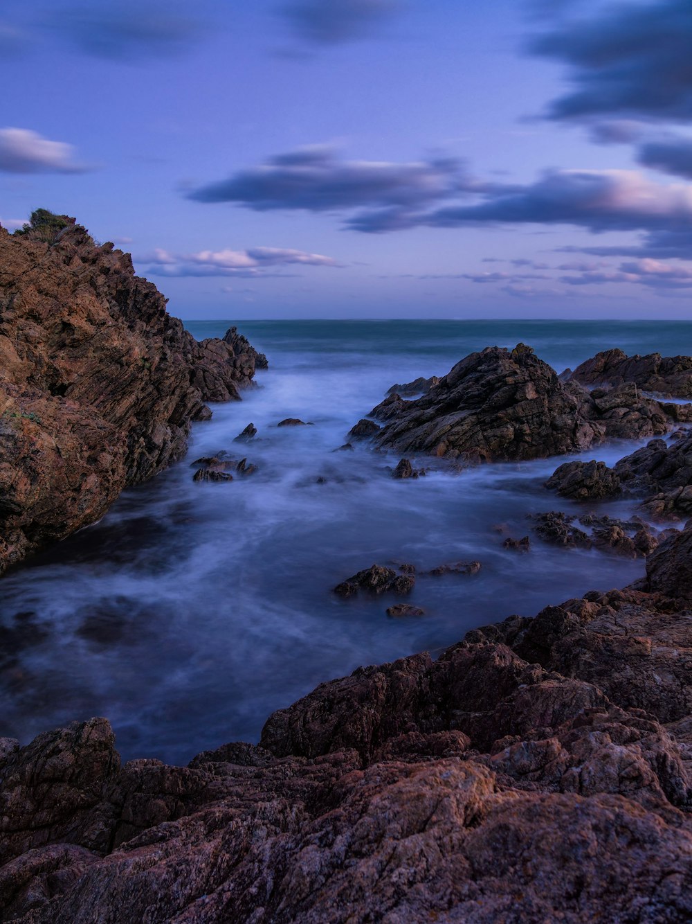 a rocky shore with a body of water