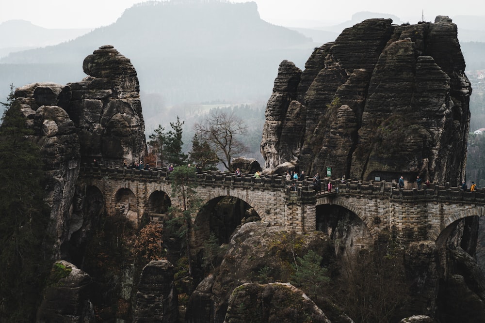 a group of people standing on top of a stone bridge