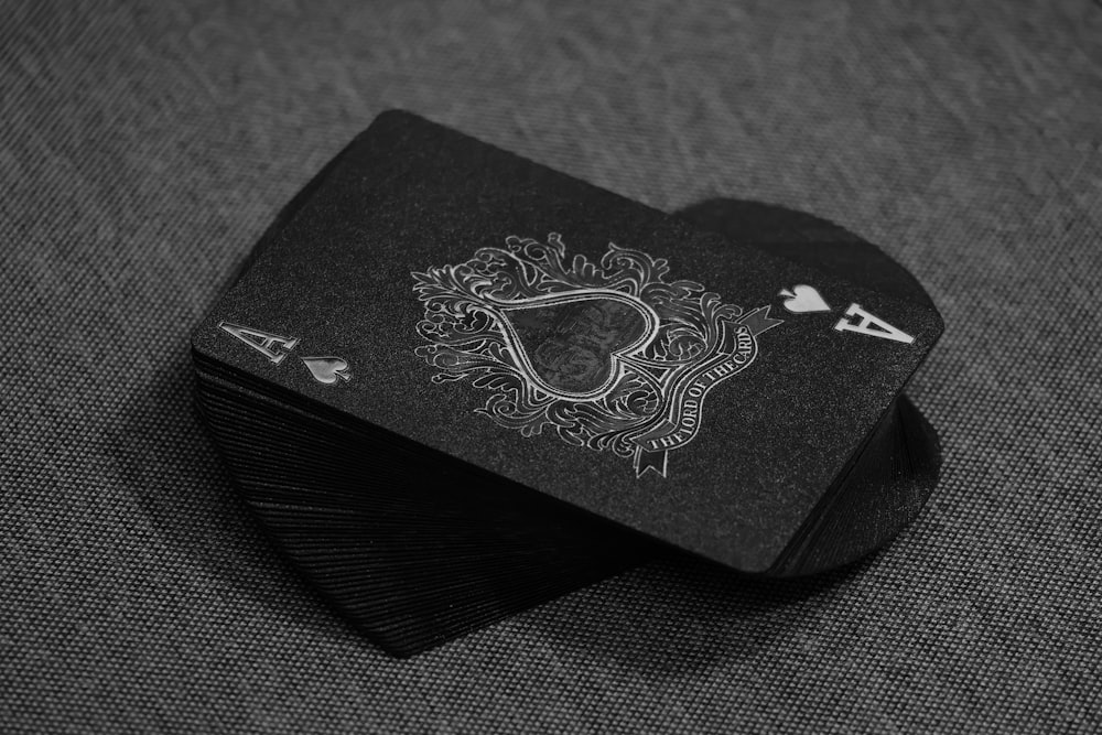 eine schwarze Spielkarte mit weißem Motiv darauf