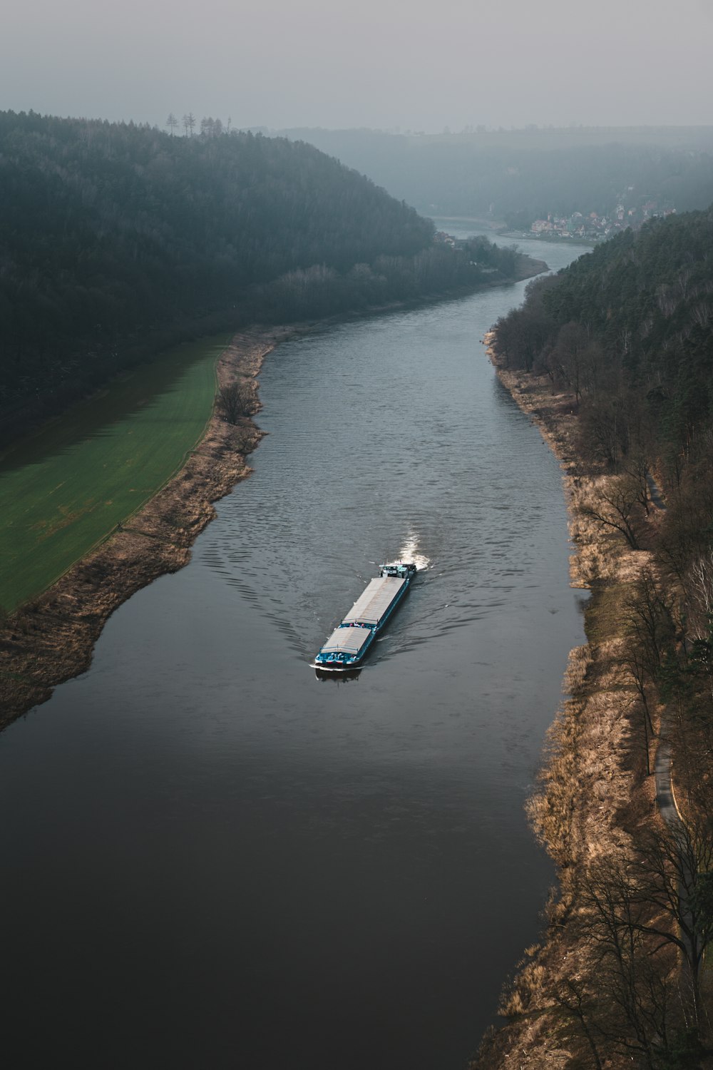 a boat is traveling down a river in the middle of the day