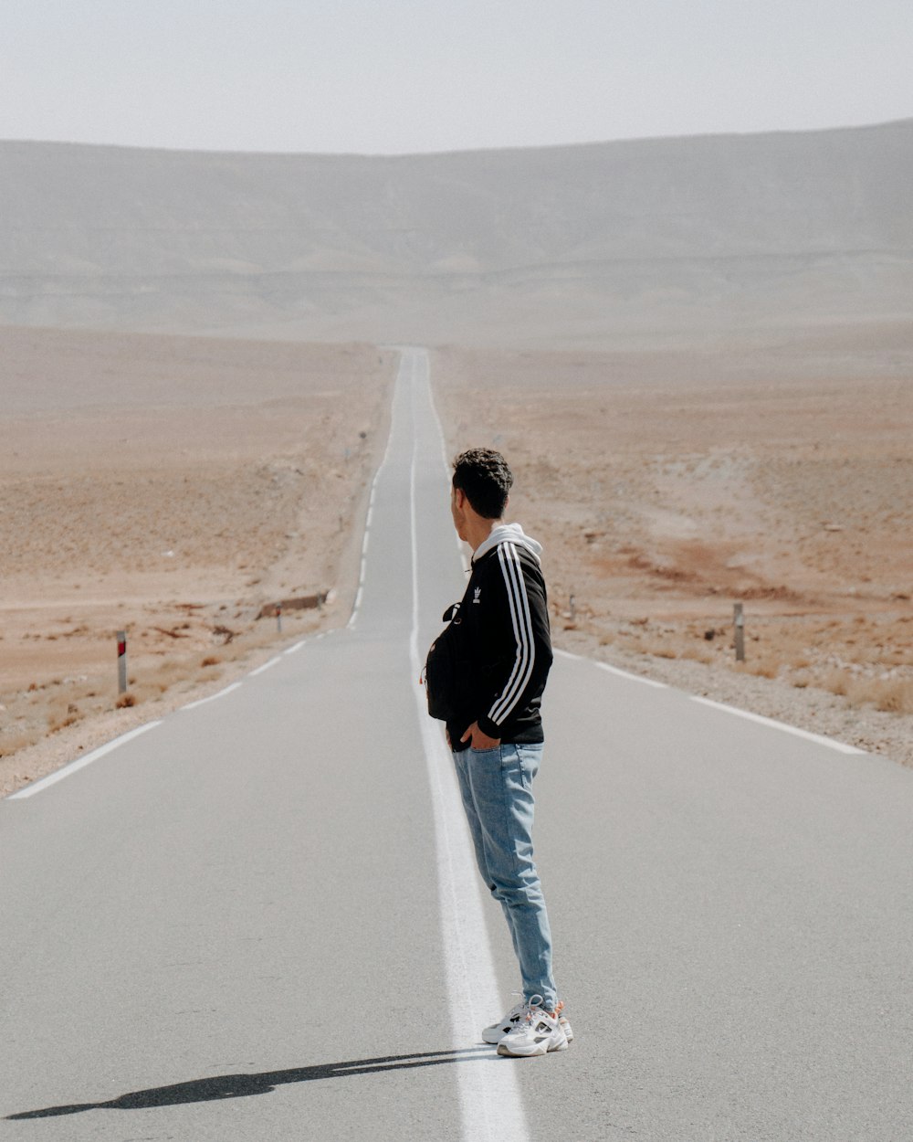 a man standing in the middle of a road