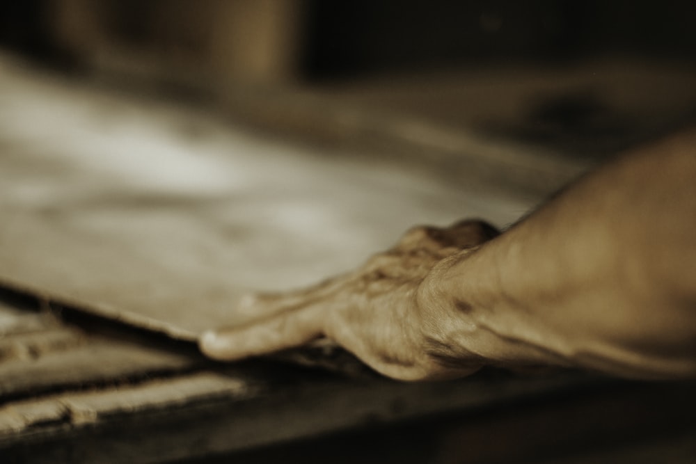 a person's hand reaching for something on a table