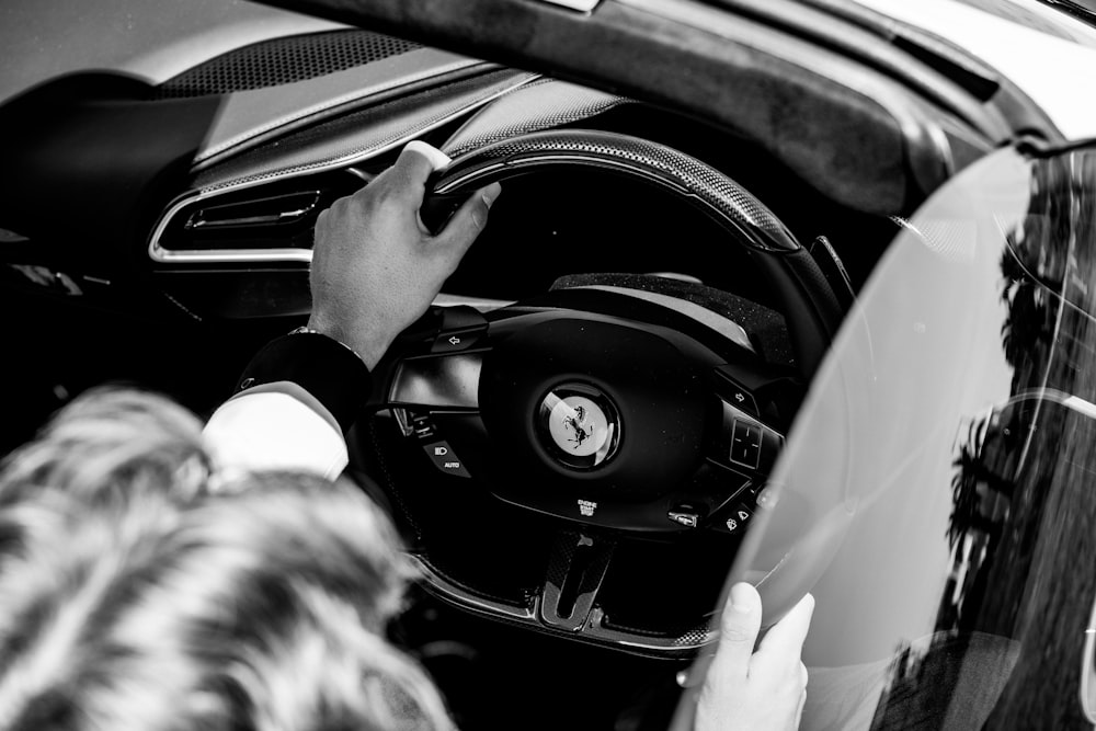 a black and white photo of a person driving a car