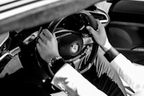 a man driving a car with his hands on the steering wheel