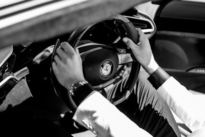 a man driving a car with his hands on the steering wheel