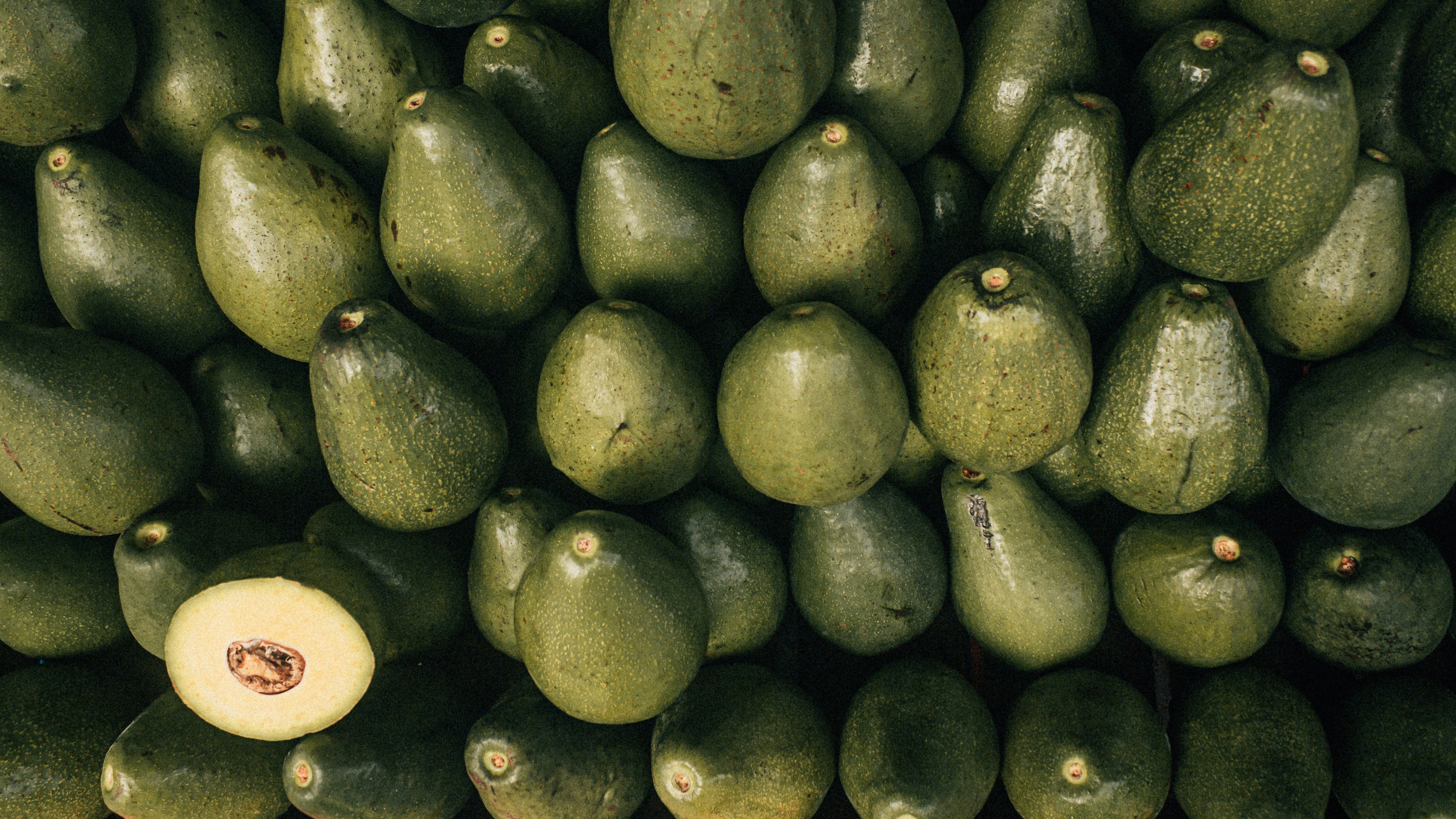 a bunch of avocados stacked up together