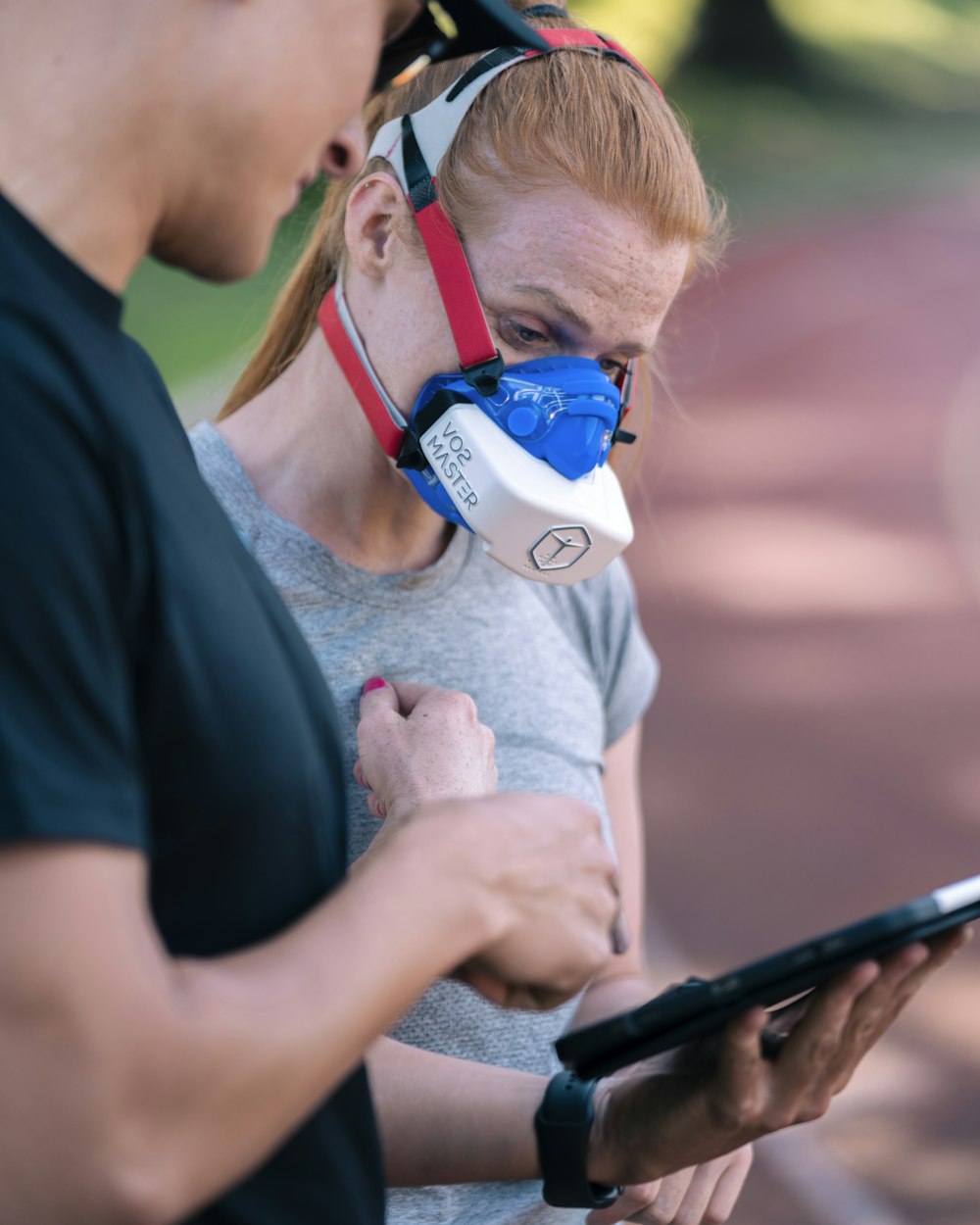 a man and a woman with a breathing mask on looking at a tablet