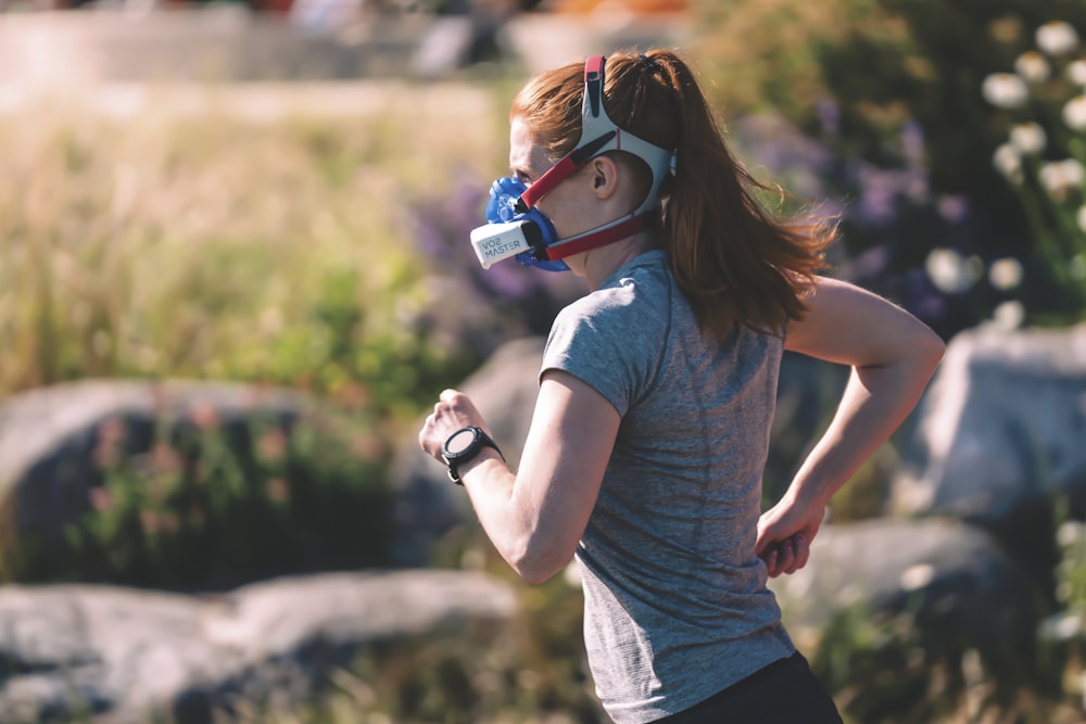 a woman wearing a mask and running in a field