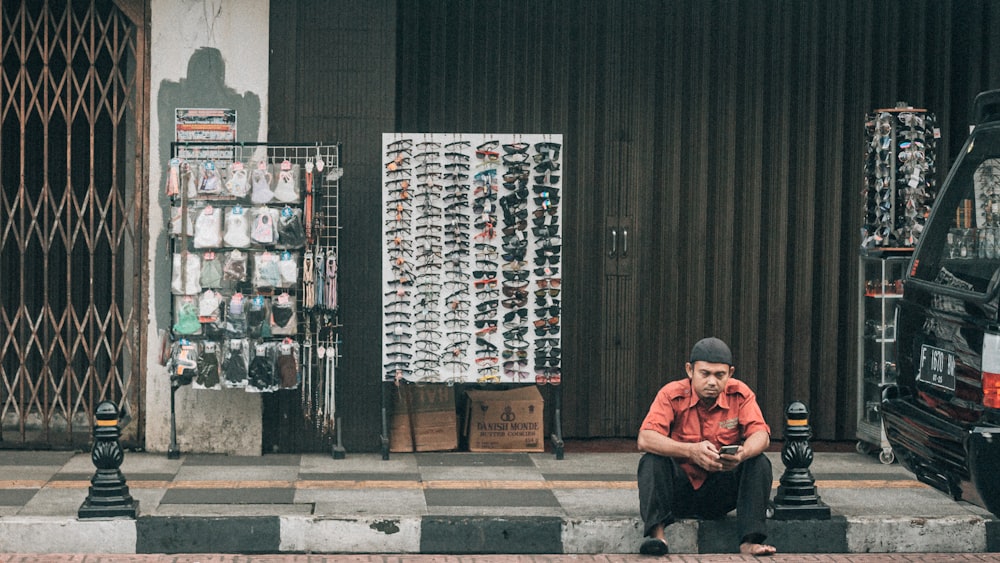 a man sitting on the curb of a street