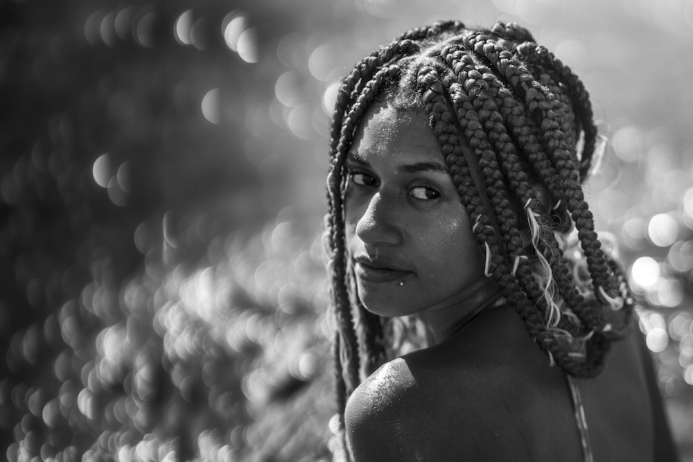 a black and white photo of a woman with braids