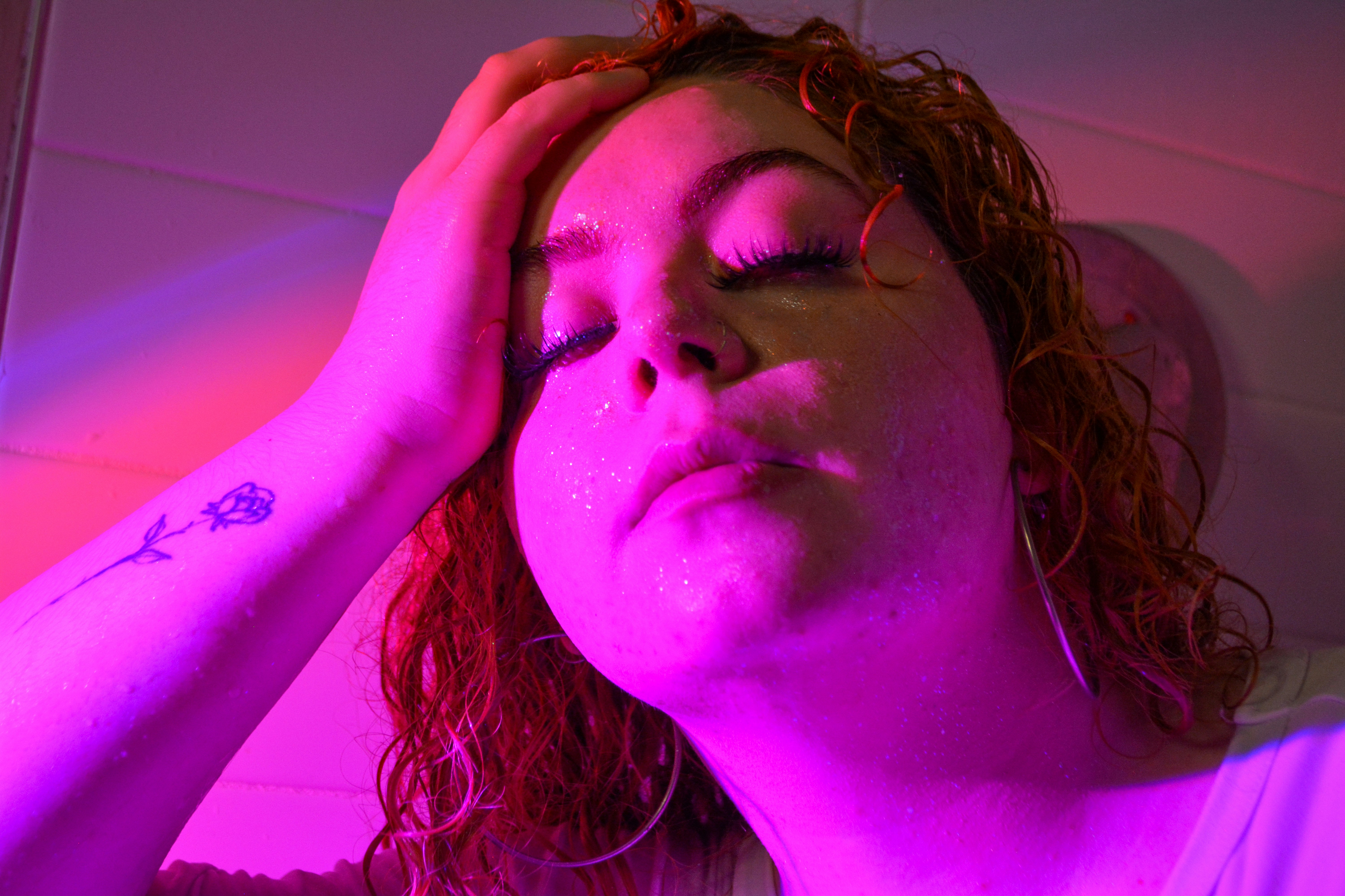 A woman with her eyes closed and her hand on her head