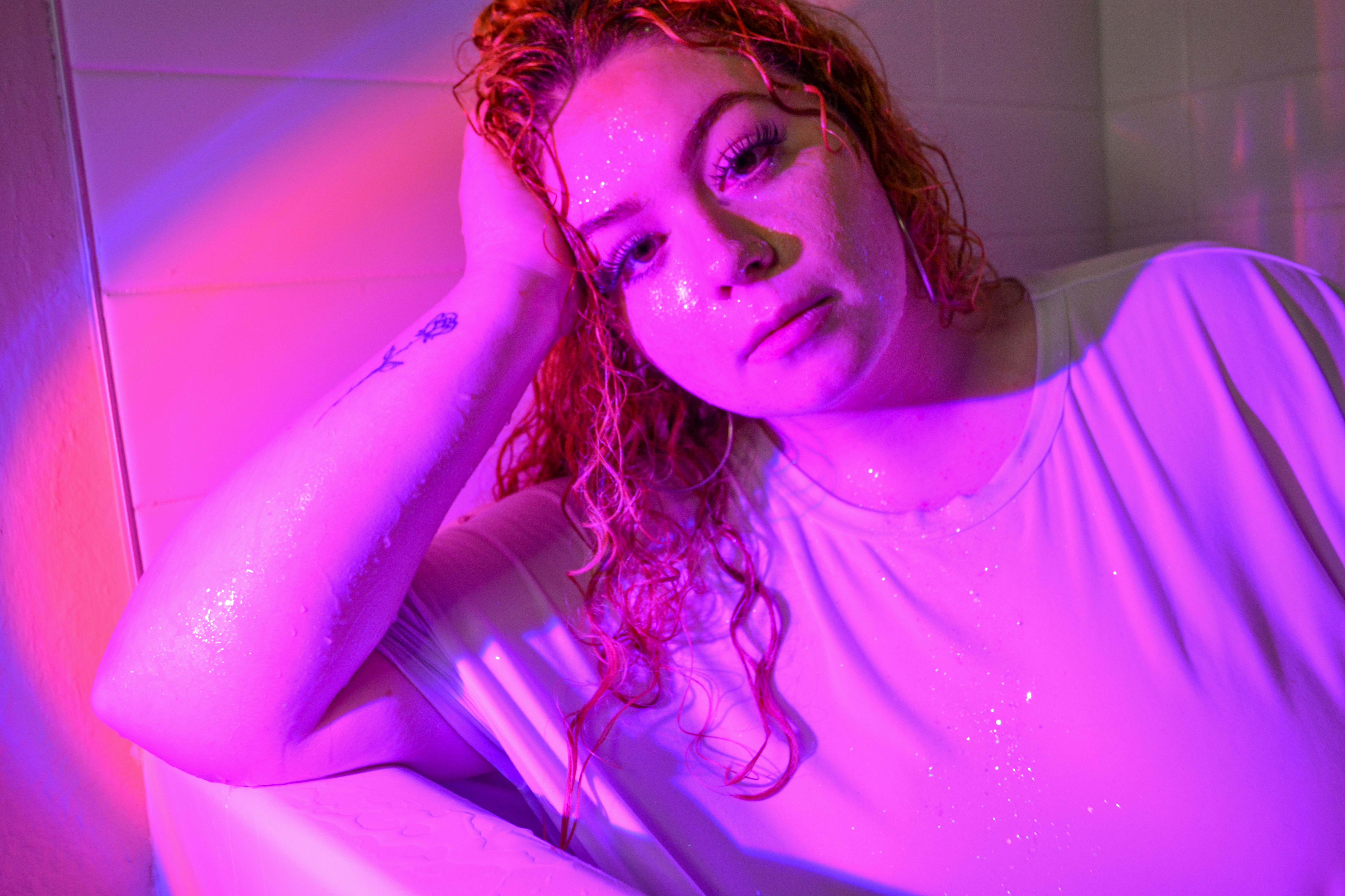 A woman with red hair sitting in a bathtub