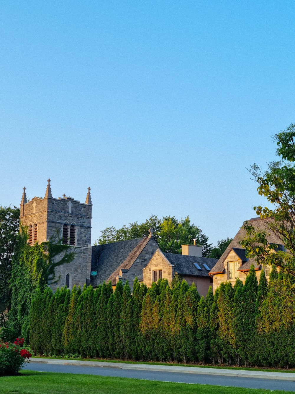 a large building with a clock tower next to a lush green field