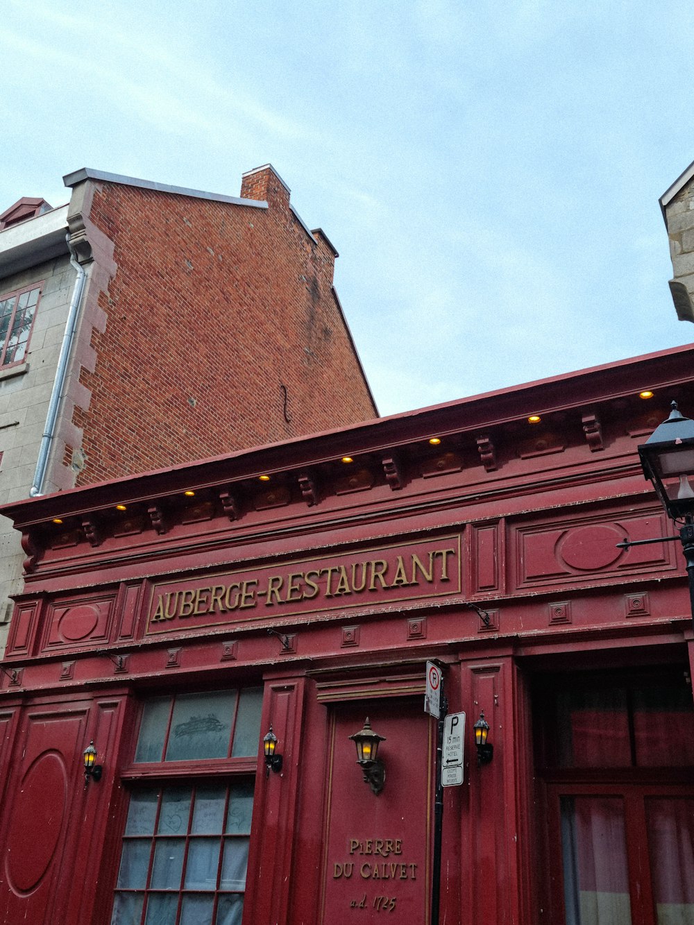 a red building with a clock on the front of it