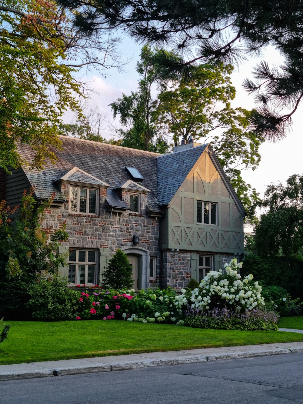 una casa grande con muchas flores frente a ella