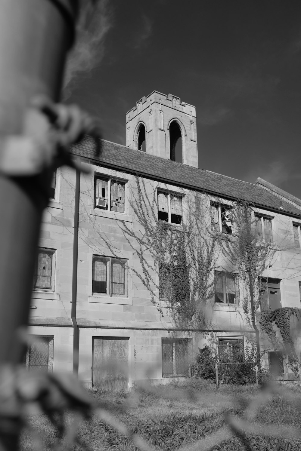 a large building with a clock tower next to a chain link fence