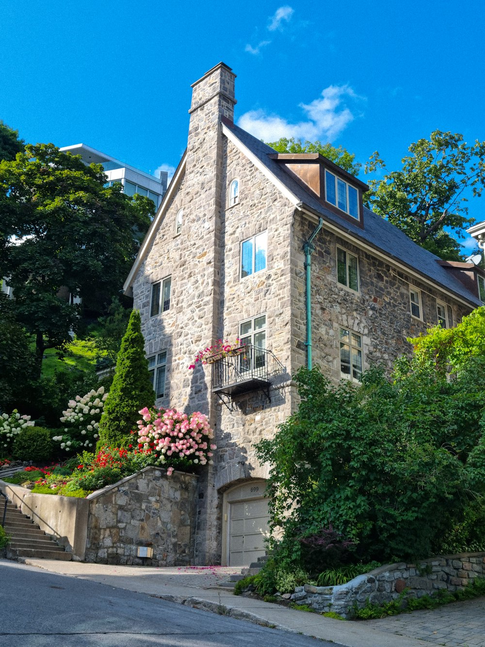 una grande casa in pietra con un campanile e fiori sulla facciata
