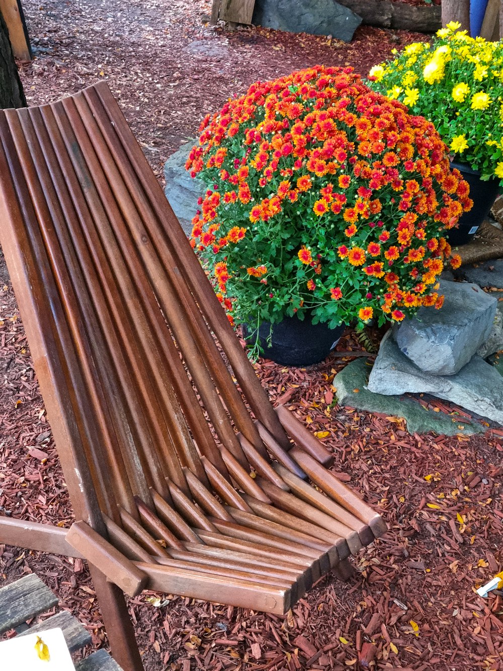 un banco de madera sentado junto a un ramo de flores