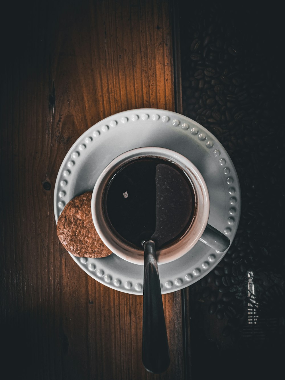 a cup of coffee and a cookie on a plate