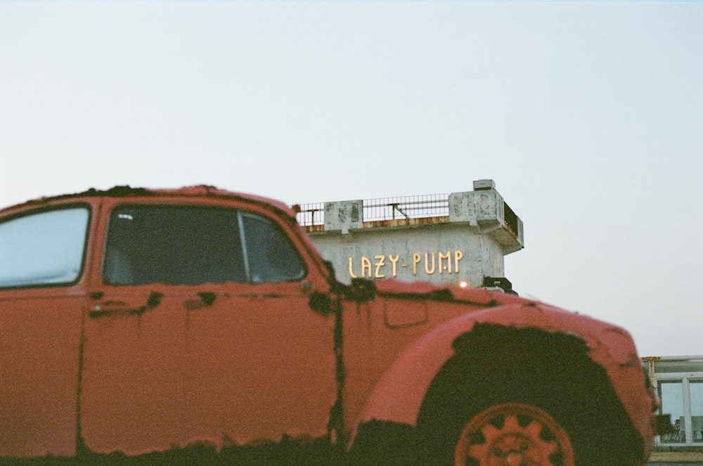 an old red truck parked in a parking lot