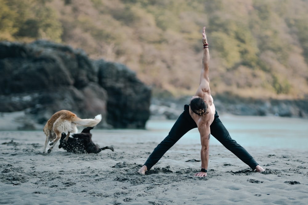 Um homem e um cachorro estão fazendo ioga na praia