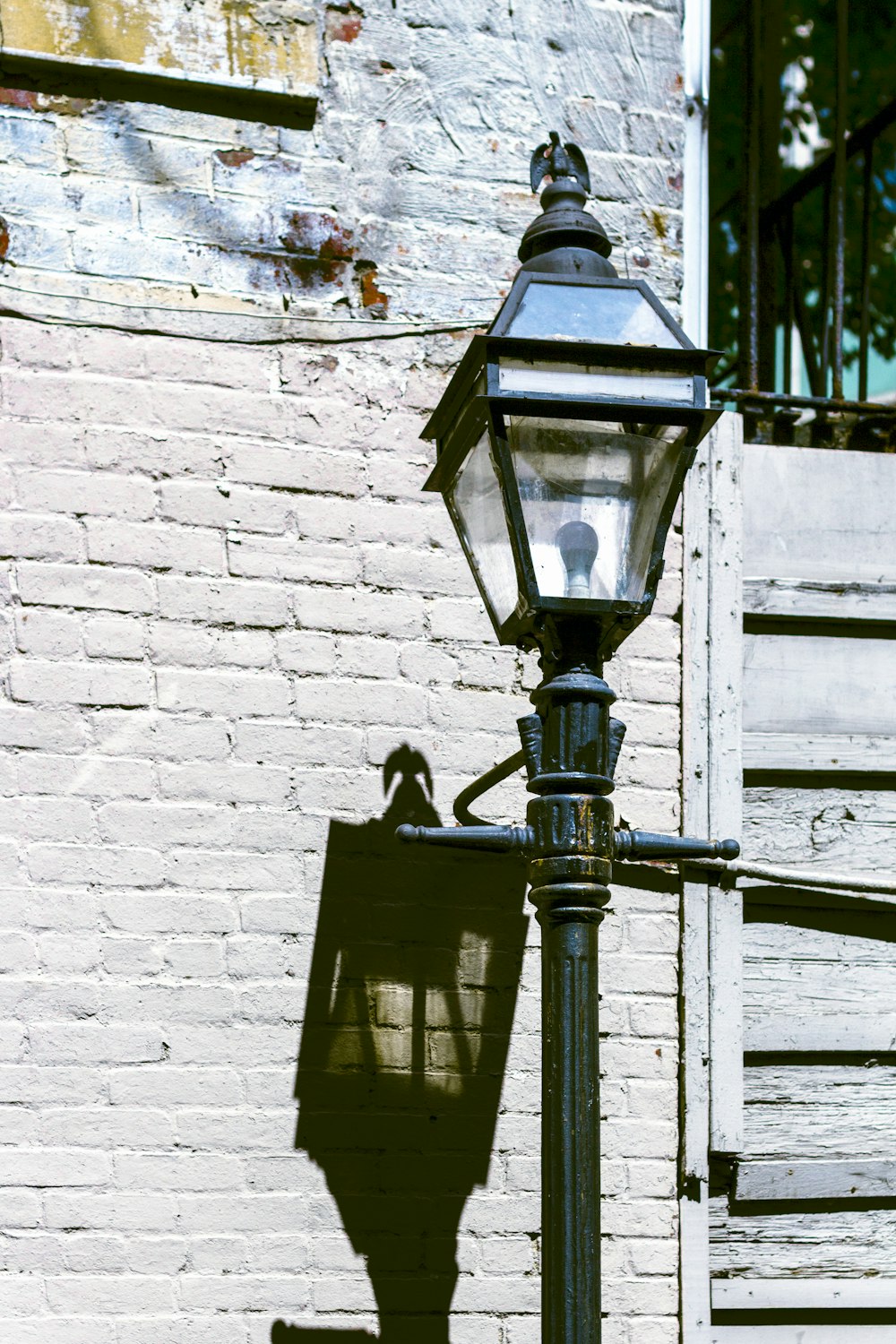 a street lamp casting a shadow on a brick wall